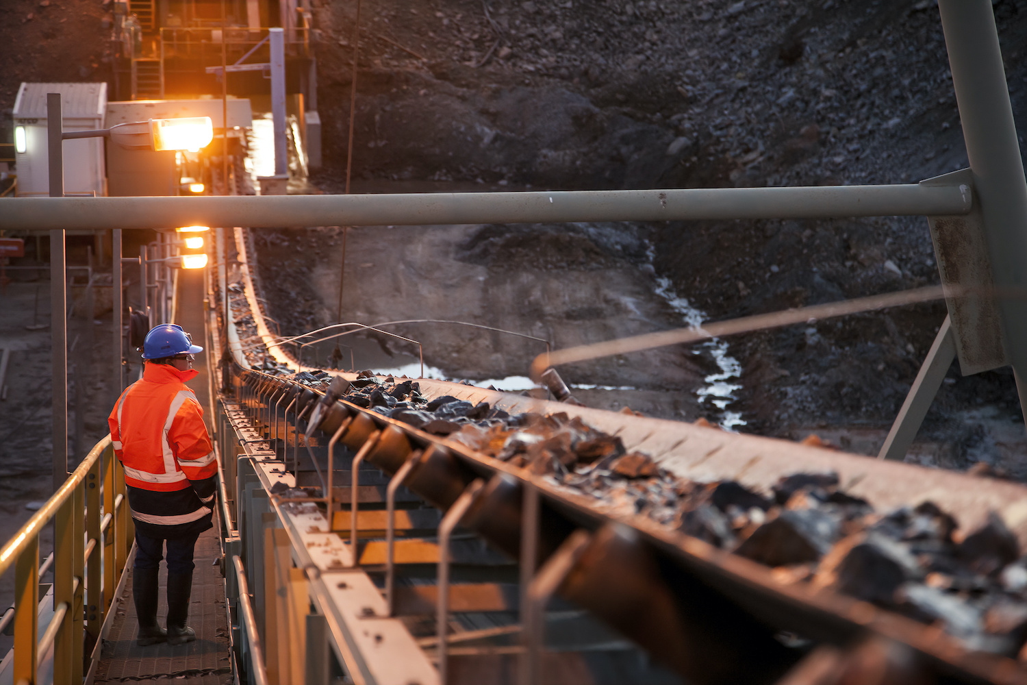 Nyngan Australia: Shallow depth of field image of a miner inspecting ore rocks on a conveyor in NSW Australia